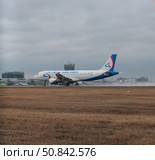 Самолет Ural Airlines садится в аэропорту Кольцово в Екатеринбурге в дождливую погоду. Редакционное фото, фотограф Ильшат Абдуллин / Фотобанк Лори