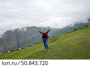 Счастливая девушка на склоне горы. Горы Кавказа облачным летним днем. Республика Дагестан, Российская Федерация. Стоковое фото, фотограф Александр Тараканов / Фотобанк Лори