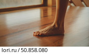 Close-up of a woman exercises bare foot on polished wooden floor near a window. Стоковое видео, видеограф Igor Tichonow / Фотобанк Лори