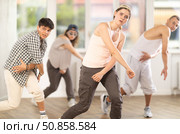 Young girl standing performs basic hip hop movements in front of group of students. Стоковое фото, фотограф Яков Филимонов / Фотобанк Лори