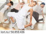 Man and his students perform hip hop dance on one bent leg, movement in horizontal plane near floor. Стоковое фото, фотограф Яков Филимонов / Фотобанк Лори