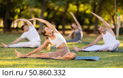 Girl leading outdoor group yoga class in summer park. Стоковое фото, фотограф Яков Филимонов / Фотобанк Лори
