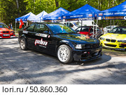 Black BMW drift car with sponsor livery in sunny paddock. Alytus, Lithuania, 25 May 2025. Редакционное фото, фотограф Zydrius Tartenis / Фотобанк Лори