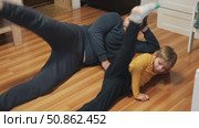 Caucasian bearded strong father with one child boy doing push ups on floor in living room. Family fitness gym at home. Sporty dad and son piggy back having fun exercise. Funny sport with kid. 4k video. Стоковое видео, видеограф Марина Демидюк / Фотобанк Лори