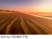 A colorful sunset or sunrise on the seaside with a sandy beach with impurities of volcanic ash. Mandrem, Goa, India. (2018 год). Стоковое фото, фотограф Емельянов Евгений Викторович / Фотобанк Лори