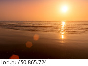 A colorful sunset or sunrise on the seaside with a sandy beach with impurities of volcanic ash. Mandrem, Goa, India. (2018 год). Стоковое фото, фотограф Емельянов Евгений Викторович / Фотобанк Лори