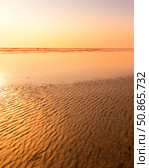 A colorful sunset or sunrise on the seaside with a sandy beach with impurities of volcanic ash. Mandrem, Goa, India. (2018 год). Стоковое фото, фотограф Емельянов Евгений Викторович / Фотобанк Лори