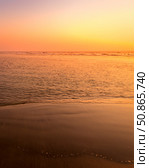 A colorful sunset or sunrise on the seaside with a sandy beach with impurities of volcanic ash. Mandrem, Goa, India. (2018 год). Стоковое фото, фотограф Емельянов Евгений Викторович / Фотобанк Лори