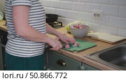 Female butcher cut raw meat with sharp knife at home kitchen. Woman cutting the chicken fillet in pieces for cooking. Preparing chopping food. Split poultry breast. Healthy lean meat, low cholesterol. Стоковое видео, видеограф Марина Демидюк / Фотобанк Лори
