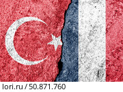 The crack between France and Turkish flags. The concept of sanctions, problems, severance of diplomatic relations and confrontation. Стоковое фото, фотограф Емельянов Евгений Викторович / Фотобанк Лори