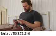 Man using his cellphone. Handsome guy use mobile phone at home. Male browses social networks, gaming, does shopping online, chats with friends, writes or reads messages. Close up. 4k video footage. Стоковое видео, видеограф Марина Демидюк / Фотобанк Лори