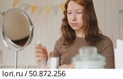Teen Girl putting on makeup looking at mirror. Beautiful Teenager caring her face. 14 years old female applied cosmetics. Natural beauty concept. Skin care, make-up. Daily make up. Beautiful Teenage. Стоковое видео, видеограф Марина Демидюк / Фотобанк Лори