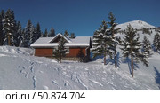 Wooden chalet nestled among snow covered pine trees, overlooking mountain landscape with sunny winter sky and distant alpine peak. Стоковое AI-видео, аниматор Данил Руденко / Фотобанк Лори