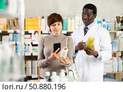 Woman buyer scans shampoo or shower gel qr code with pharmacist. Стоковое фото, фотограф Яков Филимонов / Фотобанк Лори