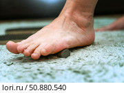 Person performing self-massage on bare foot using a small round wooden block for reflexology and relaxation. Стоковое фото, фотограф Татьяна Степанищева / Фотобанк Лори