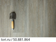 A spatula for corners on a laminated grey background. Repair concept, repair goods stores. Top down view. Copy space. Стоковое фото, фотограф Екатерина Топорова / Фотобанк Лори