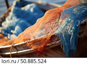 Fishing nets hanging on a boat creating colorful patterns at sunset. Стоковое AI-изображение, AI-художник Иван Рябоконь / Фотобанк Лори