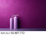 Fire extinguishers standing on floor against purple wall representing safety. Стоковое AI-изображение, AI-художник Иван Рябоконь / Фотобанк Лори