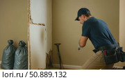 Male worker in uniform demolishing damaged interior drywall. Стоковое AI-видео, аниматор Екатерина Усенко / Фотобанк Лори