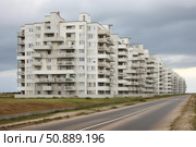 Long row of white buildings dominating the landscape under cloudy sky. Стоковое AI-изображение, AI-художник Иван Рябоконь / Фотобанк Лори