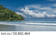 Beautiful seascape. A sunny summer day. The waves of the turquoise ocean roll towards the shore, foam on the beach. A green hill against a blue sky and clouds. Malaysia. Borneo. Kota Kinabalu. Стоковое фото, фотограф Вера Ивановна Кубарева / Фотобанк Лори
