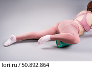 Fat woman in sportswear use myofascial release massage mfr roll on gray background, pelvic floor muscle exercise. Стоковое фото, фотограф Станислав Тарко / Фотобанк Лори