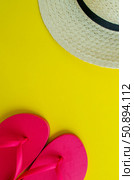 Flatlay, summer vacation. Hat and sandals on a yellow background. Vertical background. Стоковое фото, фотограф Юлия Николаева / Фотобанк Лори