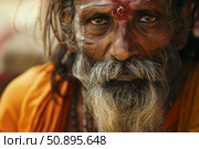 Indian sadhu wearing orange clothes and showing his face. Стоковое AI-изображение, AI-художник Иван Рябоконь / Фотобанк Лори