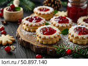 Christmas linzer cookies filled with cranberry jam on wooden board. Стоковое AI-изображение, AI-художник Иван Рябоконь / Фотобанк Лори