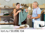 Girl discovered dress defects, is indignant and yells at senior man tailor. Стоковое фото, фотограф Яков Филимонов / Фотобанк Лори