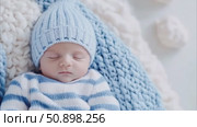 Newborn baby sleeping in blue and white knitted hat and blanket. Стоковое AI-видео, аниматор Анастасия Золотницкая / Фотобанк Лори