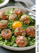 Savory Meatballs Plated With Fresh Herbs and a Raw Egg Yolk Nestled in the Center. Стоковое AI-изображение, AI-художник Юлия Гапеенко / Фотобанк Лори