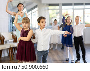 Enthusiastic preteen children dancing waltz in pairs in dance school. Стоковое фото, фотограф Яков Филимонов / Фотобанк Лори