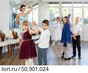 Enthusiastic preteen children dancing waltz in pairs in dance school. Стоковое фото, фотограф Яков Филимонов / Фотобанк Лори