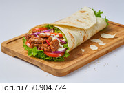 Шаурма с овощами и мясом на деревянной доске. Стоковое AI-изображение, AI-художник Ирина Савостикова / Фотобанк Лори