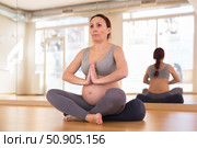 Pregnant woman is engaged in yoga. Easy pose or sukhasana. Стоковое фото, фотограф Татьяна Яцевич / Фотобанк Лори