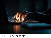 Person typing at laptop computer at night. Female uses keyboard, shakes buttons with fingers. Internet security, cyber attack. Trendy neon light. Creative dark color of orange, black, and teal blue. Стоковое AI-изображение, AI-художник Марина Демидюк / Фотобанк Лори