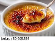 Creme brulee. dessert with caramel crust. Elegant Gourmet Dessert with Caramelized Sugar Crust. French vanilla cream. Eating Creme Brulee with Spoon. Cracking caramel. Delicious Sweet. Catalan cream. Стоковое AI-изображение, AI-художник Марина Демидюк / Фотобанк Лори