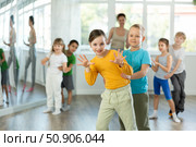 Group of children training movements of twist in dance studio with female teacher. Стоковое фото, фотограф Яков Филимонов / Фотобанк Лори