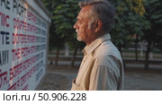 Mature voter studying constitutional text, reflecting on democratic values and civic engagement while standing near historical document display. Стоковое AI-видео, аниматор Данил Руденко / Фотобанк Лори