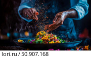 Chef Preparation: A culinary professional seasons a vibrant salad with a sprinkle of spices, adding the finishing touch to a fresh and colorful dish. Стоковое AI-изображение, AI-художник Данила Большаков / Фотобанк Лори
