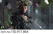 Intense close-up of a model with intricate floral headpiece and dramatic outfit in a moody setting. Стоковое AI-видео, аниматор Сергей Толмачёв / Фотобанк Лори