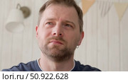 Handsome young man in blue jersey indoors. Male with stylish haircut, beard feel happy, calm and serious. Home interior background. Man looking to camera and into distance. Diversity People. Portrait. Стоковое видео, видеограф Марина Демидюк / Фотобанк Лори