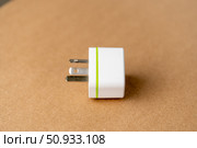 A white charger with a green stripe sits on a brown surface. Стоковое фото, фотограф Скрипачев Антон / Фотобанк Лори