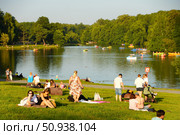 Vacationers on the green lawn by the pond in Kuzminki Park. Russia. Moscow. 25.07.25. Редакционное фото, фотограф Ярославский Максим / Фотобанк Лори