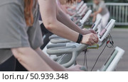 Athletes pedaling on exercise bikes during sports day. Стоковое видео, видеограф Mikhail Davidovich / Фотобанк Лори