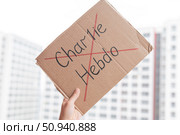 2 November 2020 France Paris: A man holds a cardboard poster with charlie hebdo crossed out. Редакционное фото, фотограф Михаил Решетников / Фотобанк Лори