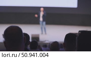 Audience observing a speaker presenting on stage in a conference setting. Стоковое видео, видеограф Антон Гвоздиков / Фотобанк Лори