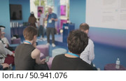 Audience observing a presentation with multimedia visuals in a modern setting. Стоковое видео, видеограф Антон Гвоздиков / Фотобанк Лори