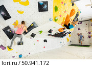 Woman and man alpinists practicing in pair indoor rock-climbing on climbing wall. Стоковое фото, фотограф Яков Филимонов / Фотобанк Лори